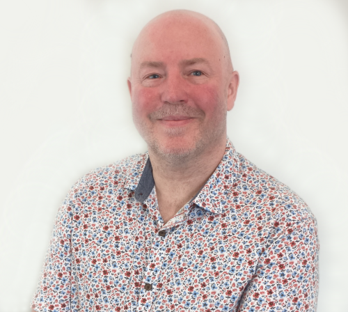 Court of Protection Solicitor Simon Heapy wearing a multi-coloured spotted shirt.