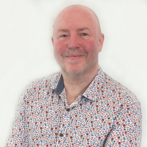 Court of Protection Solicitor Simon Heapy wearing a multi-coloured spotted shirt.